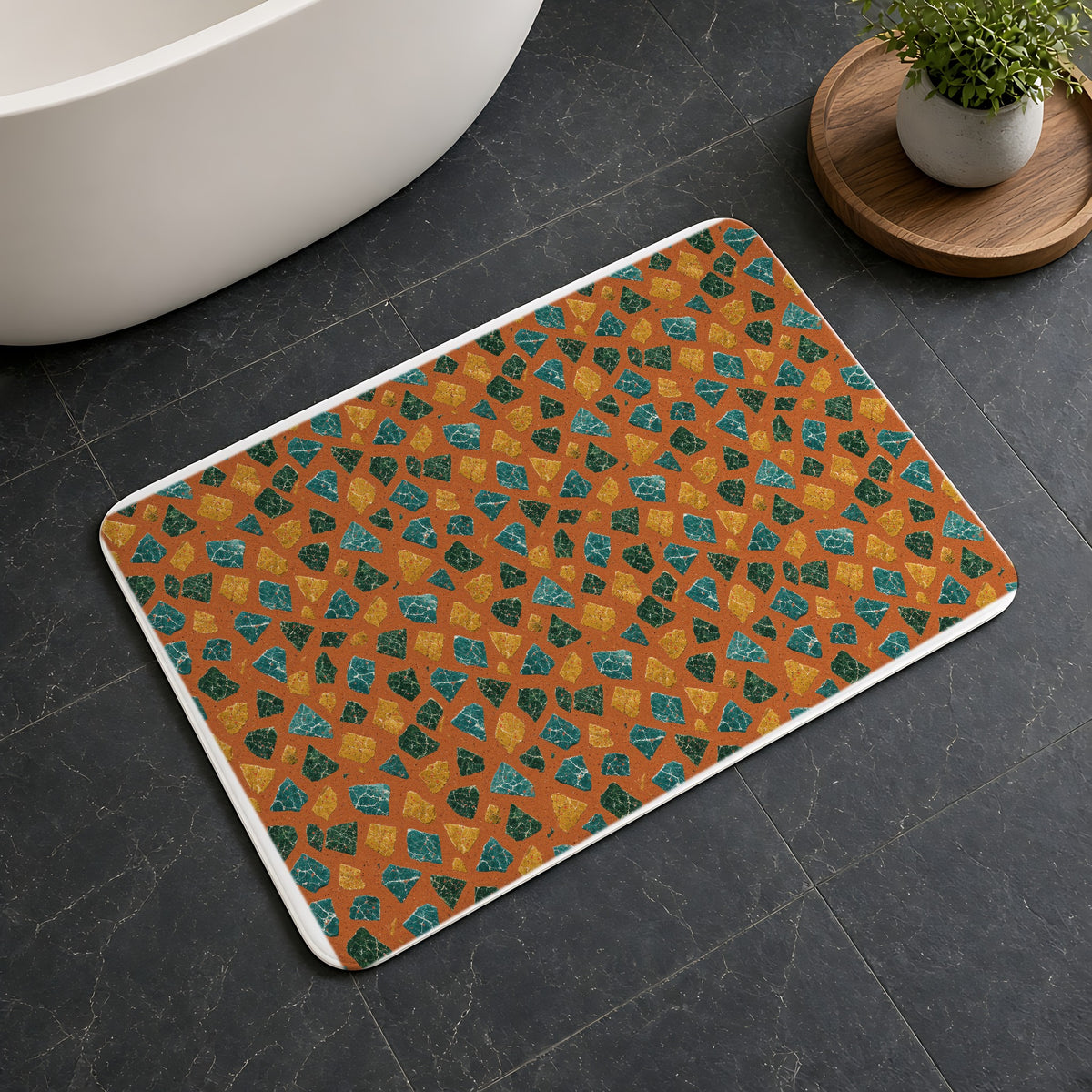 Marble Fragment Toss Bath Mat on a dark slate floor beside a bath