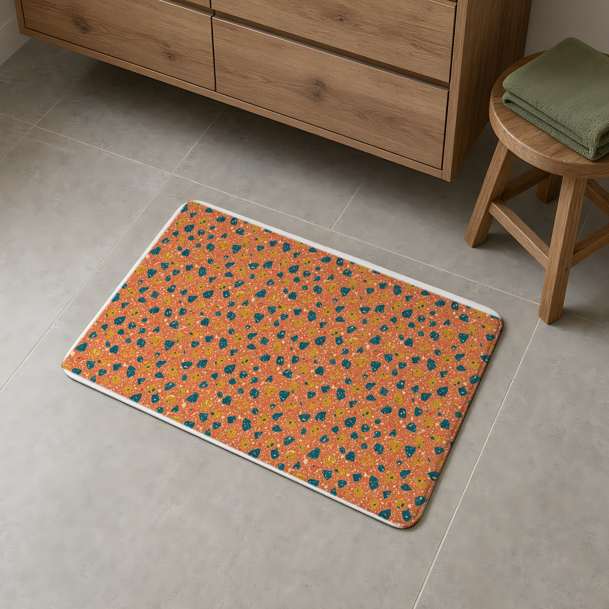 Two-Scale Chips Bath Mat on a grey tiled bathroom floor