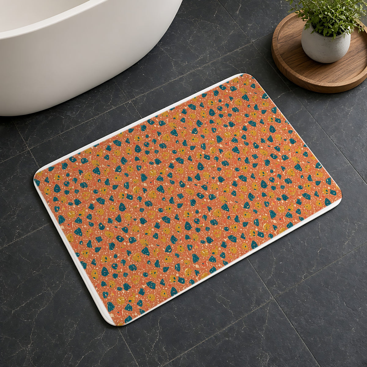 Two-Scale Chips Bath Mat on a dark slate floor beside a bath