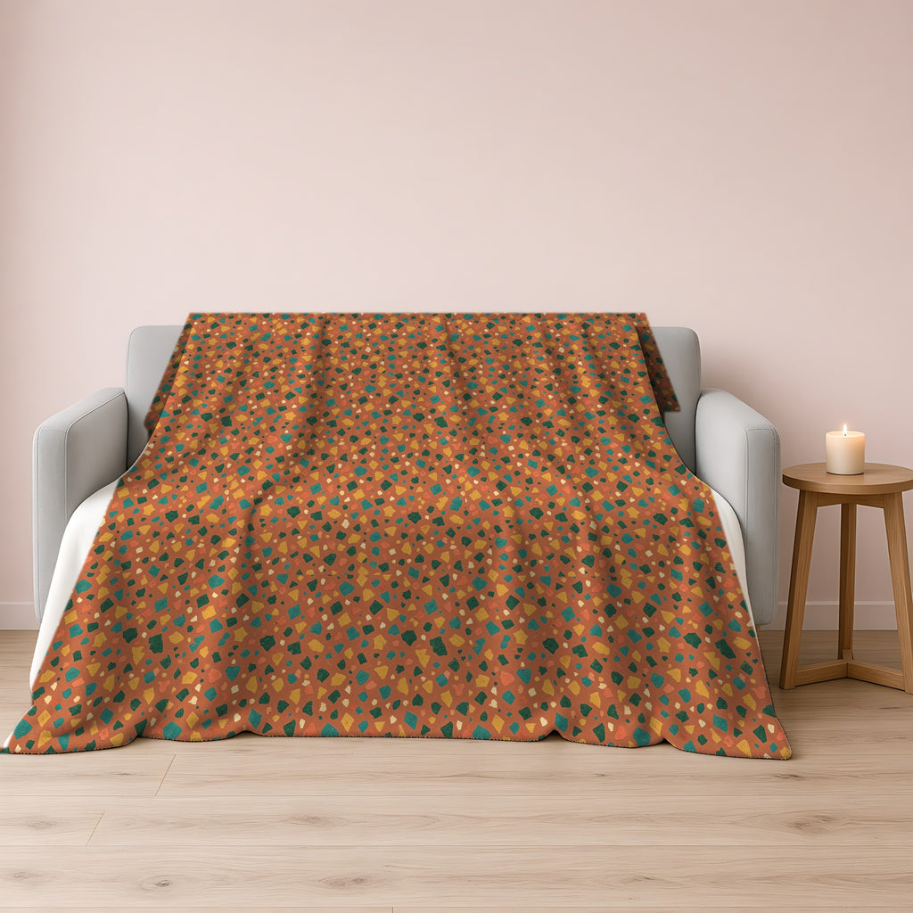 Jewel Chip Terrazzo Sherpa Fleece Blanket draped over a grey sofa