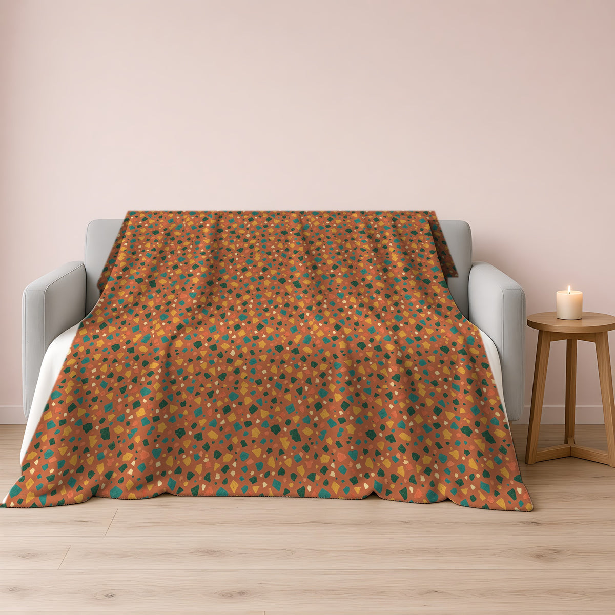 Jewel Chip Terrazzo Sherpa Fleece Blanket draped over a grey sofa