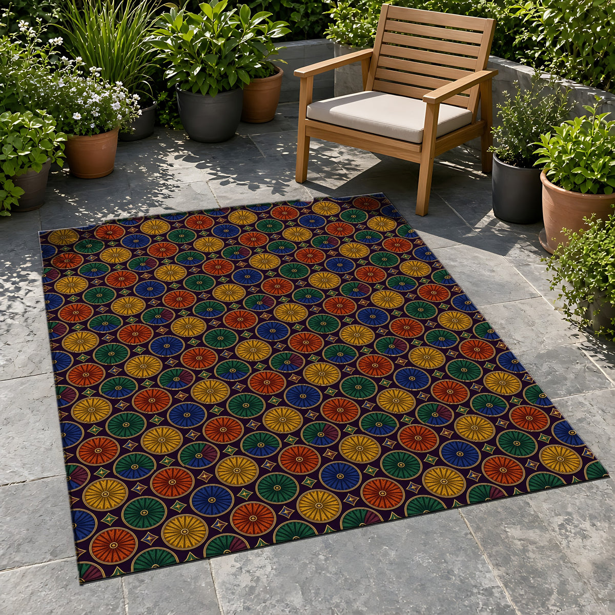 Enamel Parasol Medallions Outdoor Rug on a stone patio with potted plants