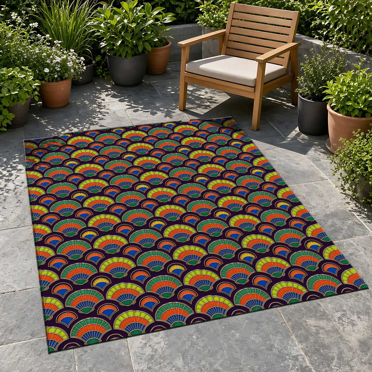 Deco Fan Scales Outdoor Rug on a stone patio with potted plants