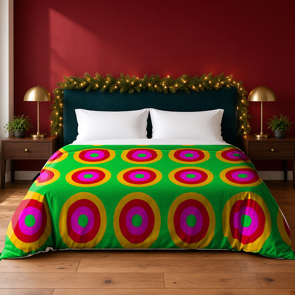 Giant Op-Art Jewel Rings cotton duvet cover in the Christmas Jewel Bright palette, on a bed with a green headboard in a festive bedroom with pine garland and fairy lights