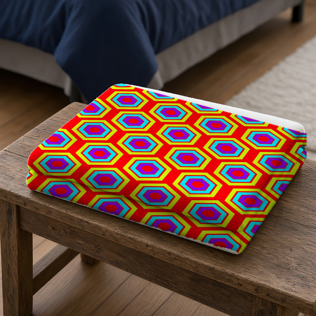 Concentric Hexagon Ripple Sherpa Fleece Blanket folded on a wooden bench