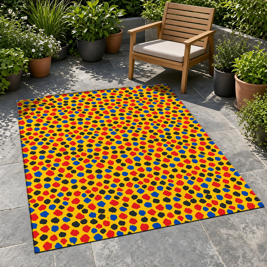 Confetti Scraps Yellow Outdoor Rug on a stone patio with potted plants