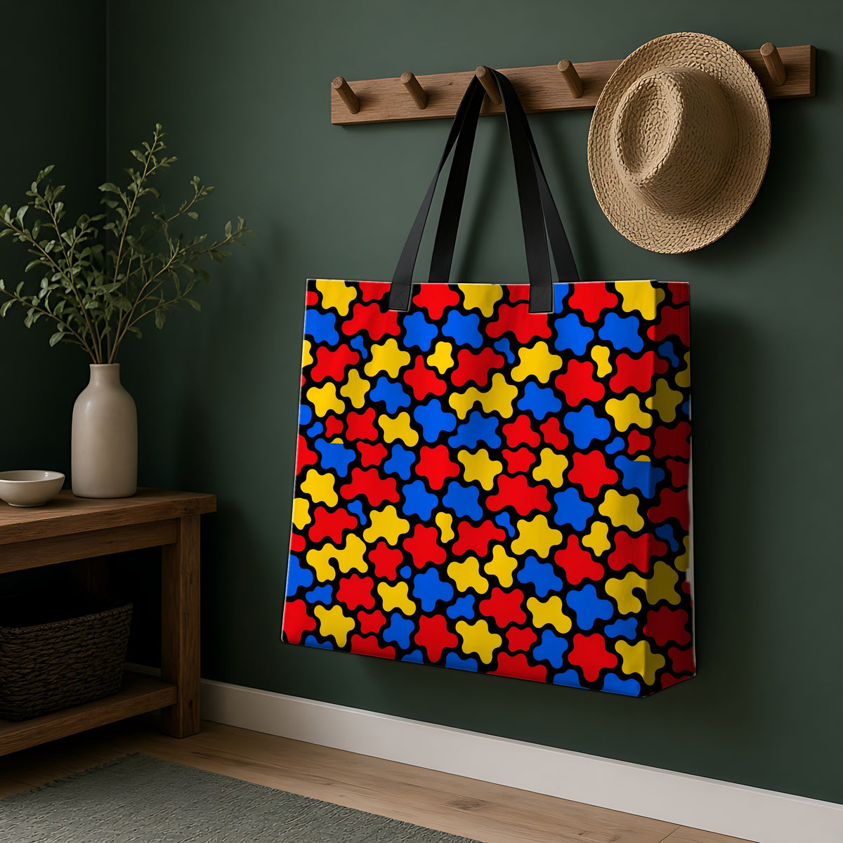 Blob Black Weekender Tote Bag hanging on a peg rail in a green hallway