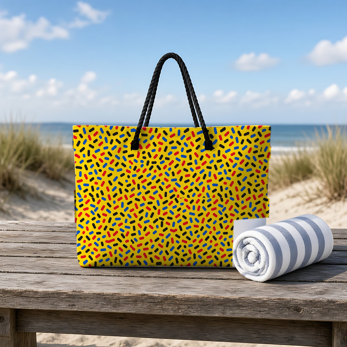 Sprinkle Pop Weekender Tote Bag on a rustic table by the beach