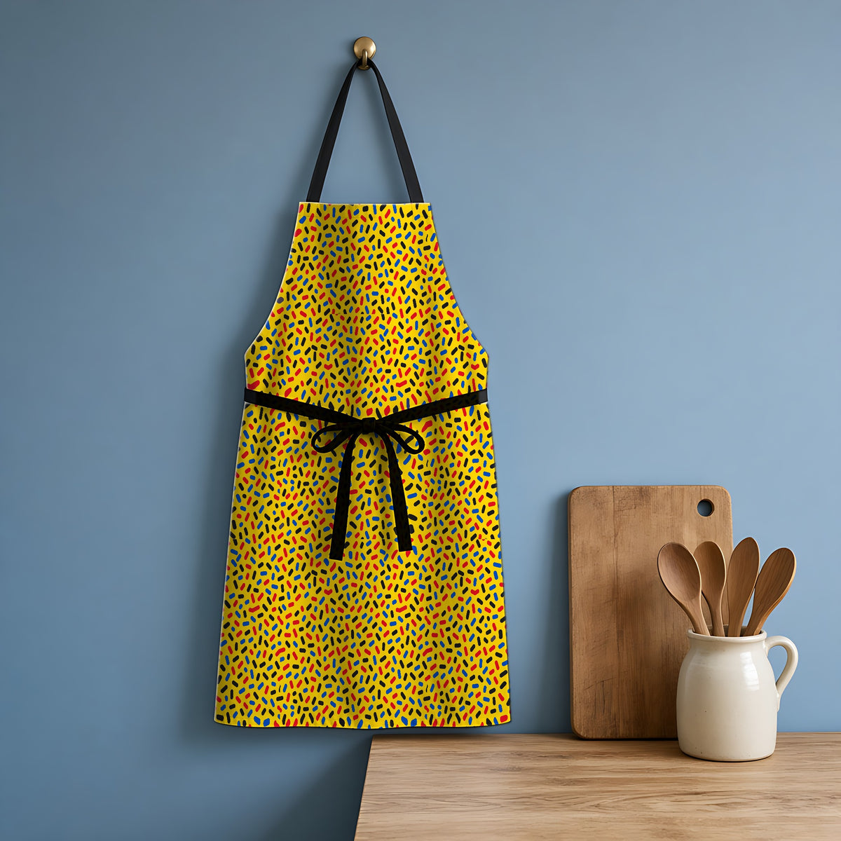 Sprinkle Pop Apron hanging in a blue kitchen