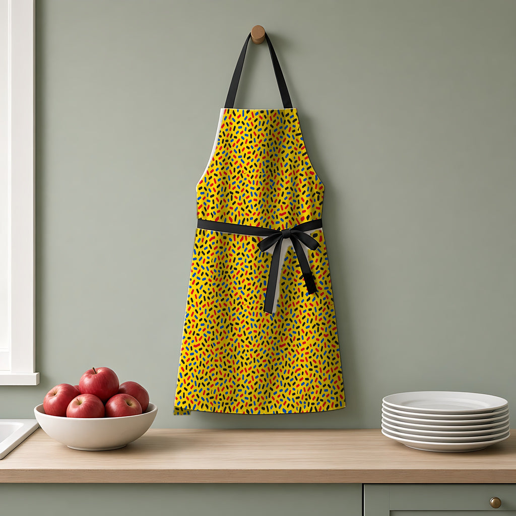Sprinkle Pop Apron hanging on a sage-green kitchen wall