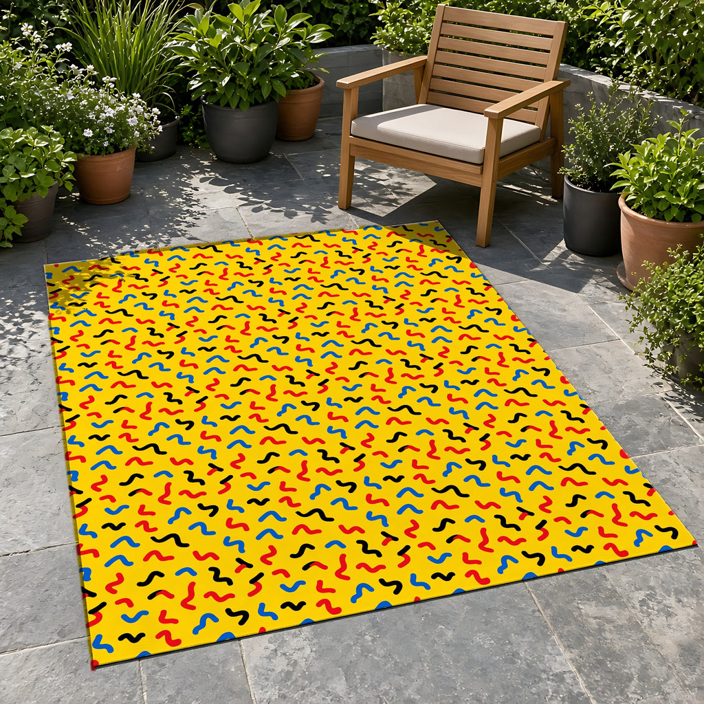 Squiggle Strokes Yellow Outdoor Rug on a stone patio with potted plants