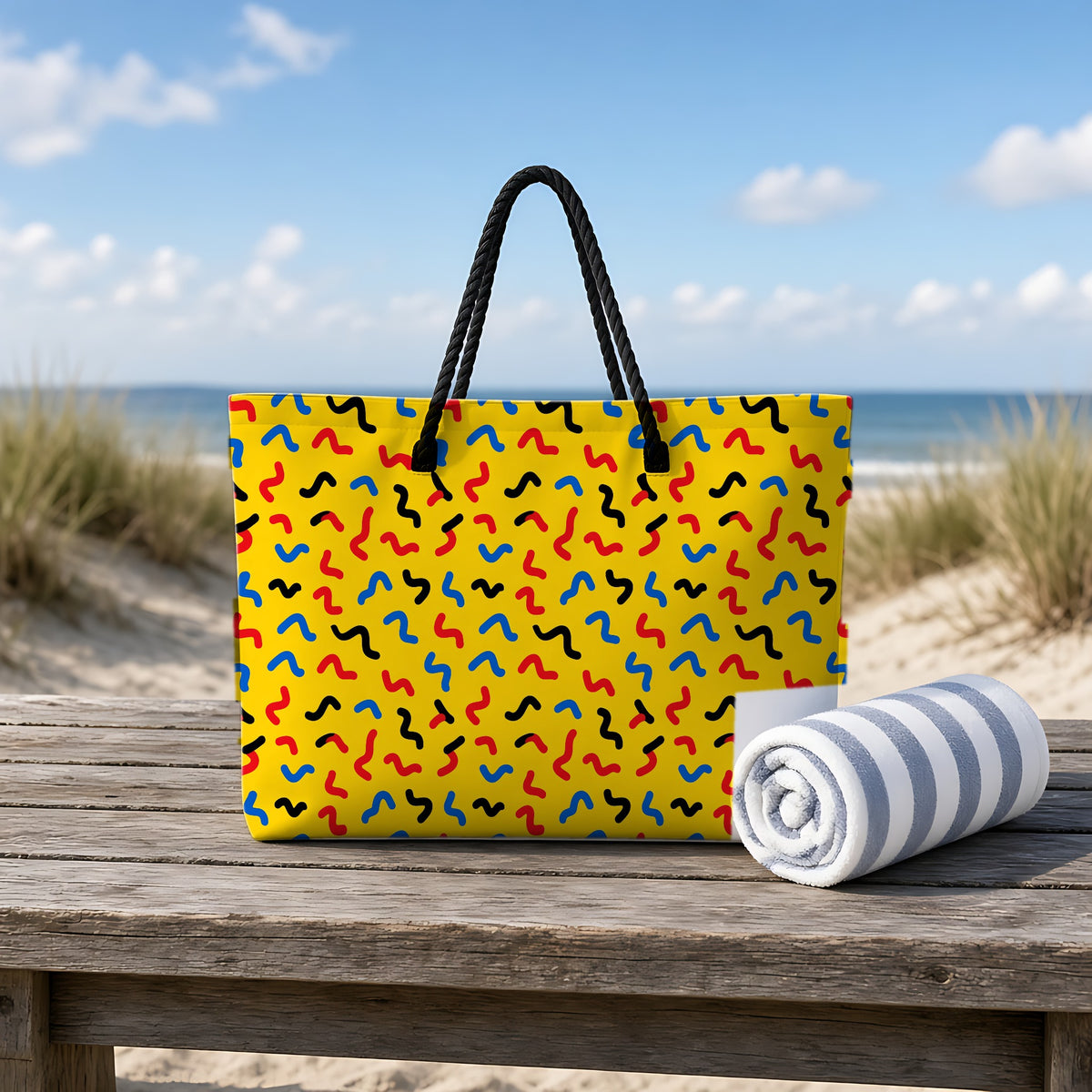 Squiggle Strokes Yellow Weekender Tote Bag on a rustic table by the beach
