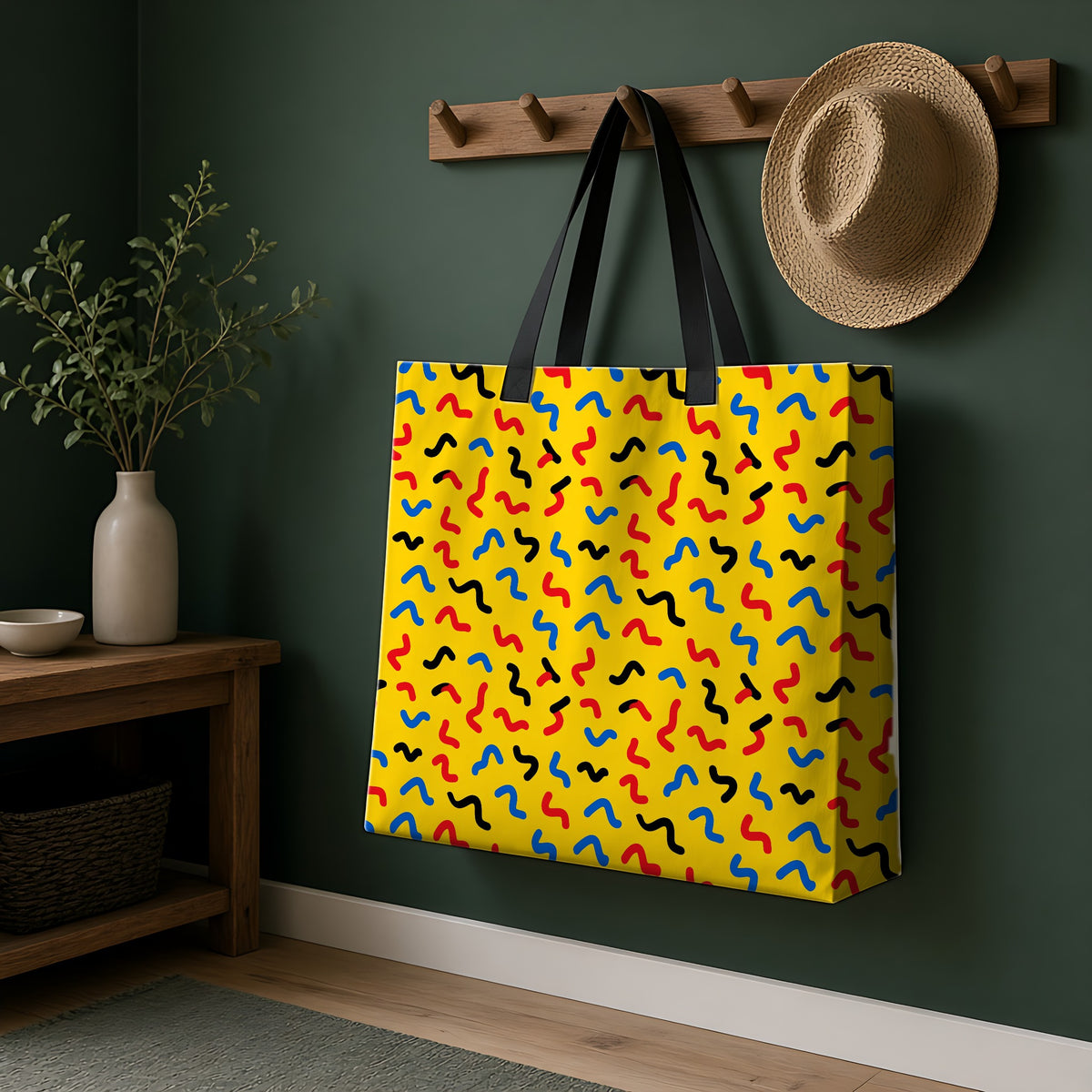 Squiggle Strokes Yellow Weekender Tote Bag hanging on a peg rail in a green hallway