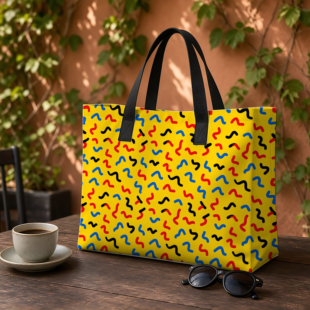 Squiggle Strokes Yellow Weekender Tote Bag on a garden café table