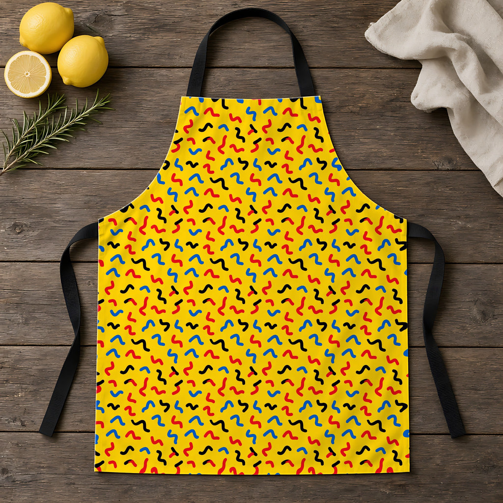 Squiggle Strokes Yellow Apron laid flat on a rustic wooden table