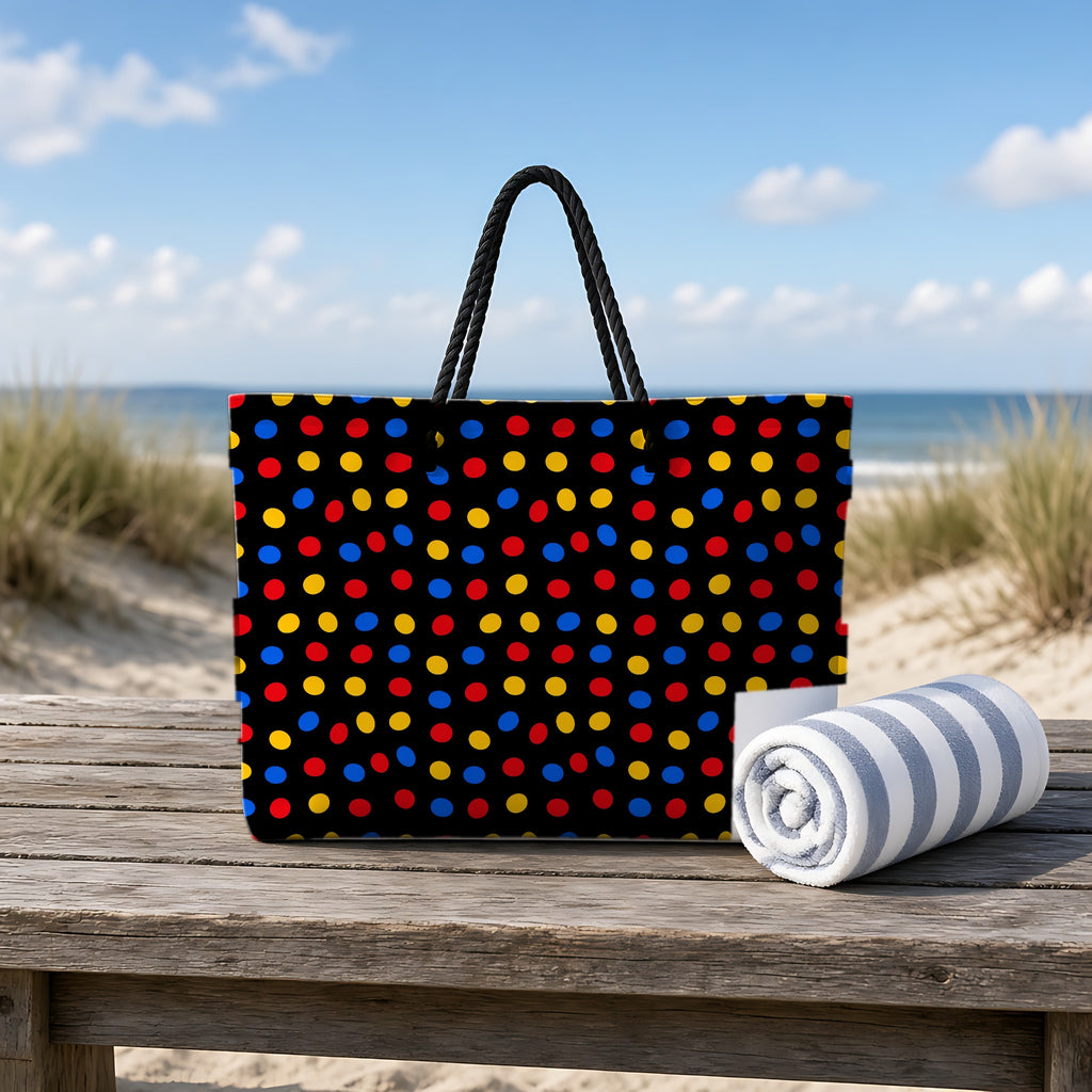 Pebble Scatter Black Weekender Tote Bag on a rustic table by the beach