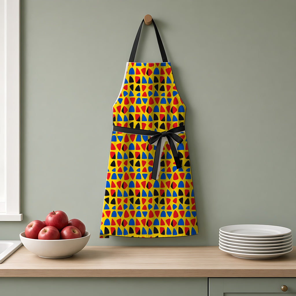 Cut-Out Arcs Yellow Apron hanging on a sage-green kitchen wall