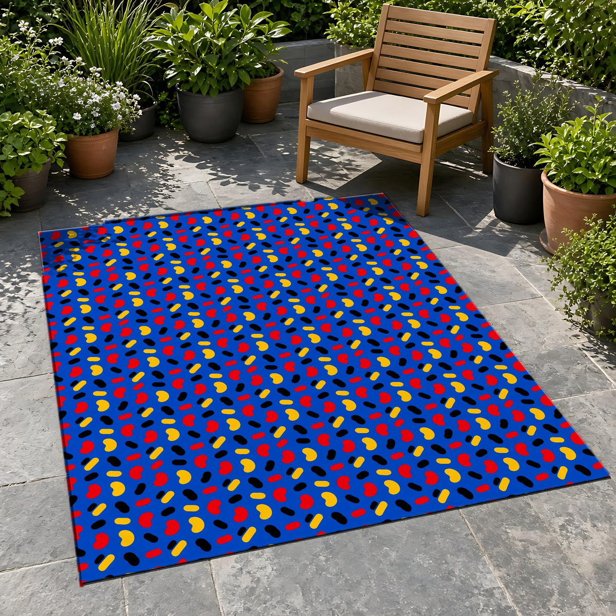 Bean Scatter Blue Outdoor Rug on a stone patio with potted plants