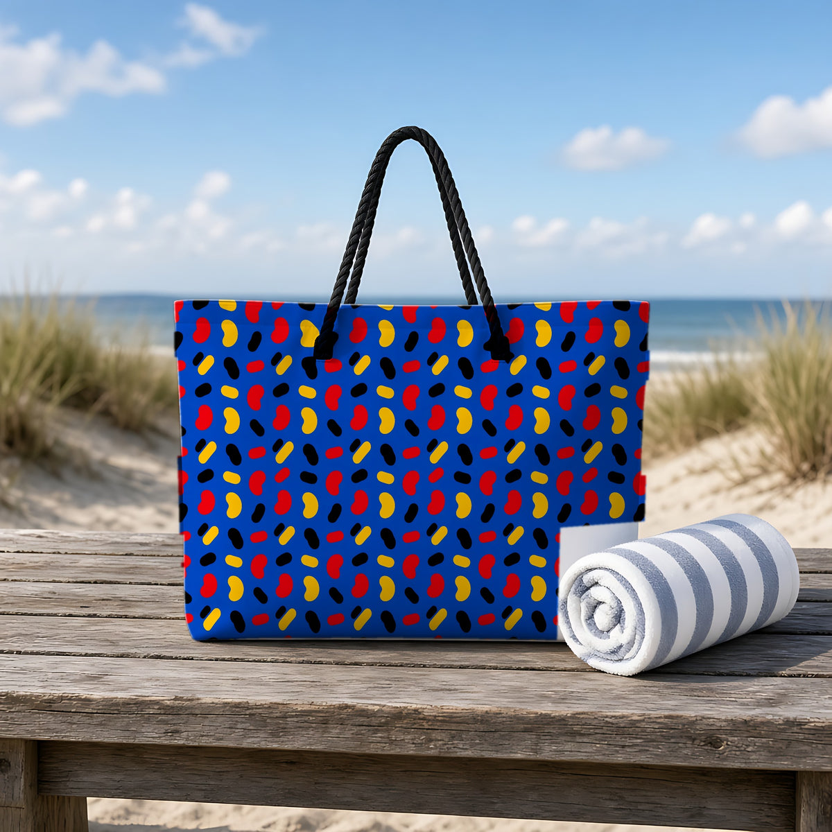 Bean Scatter Blue Weekender Tote Bag on a rustic table by the beach