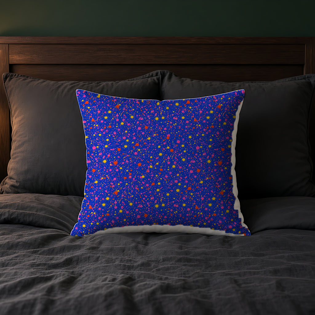 Ultramarine Spatter Faux Suede Cushion on a bed with charcoal bedding