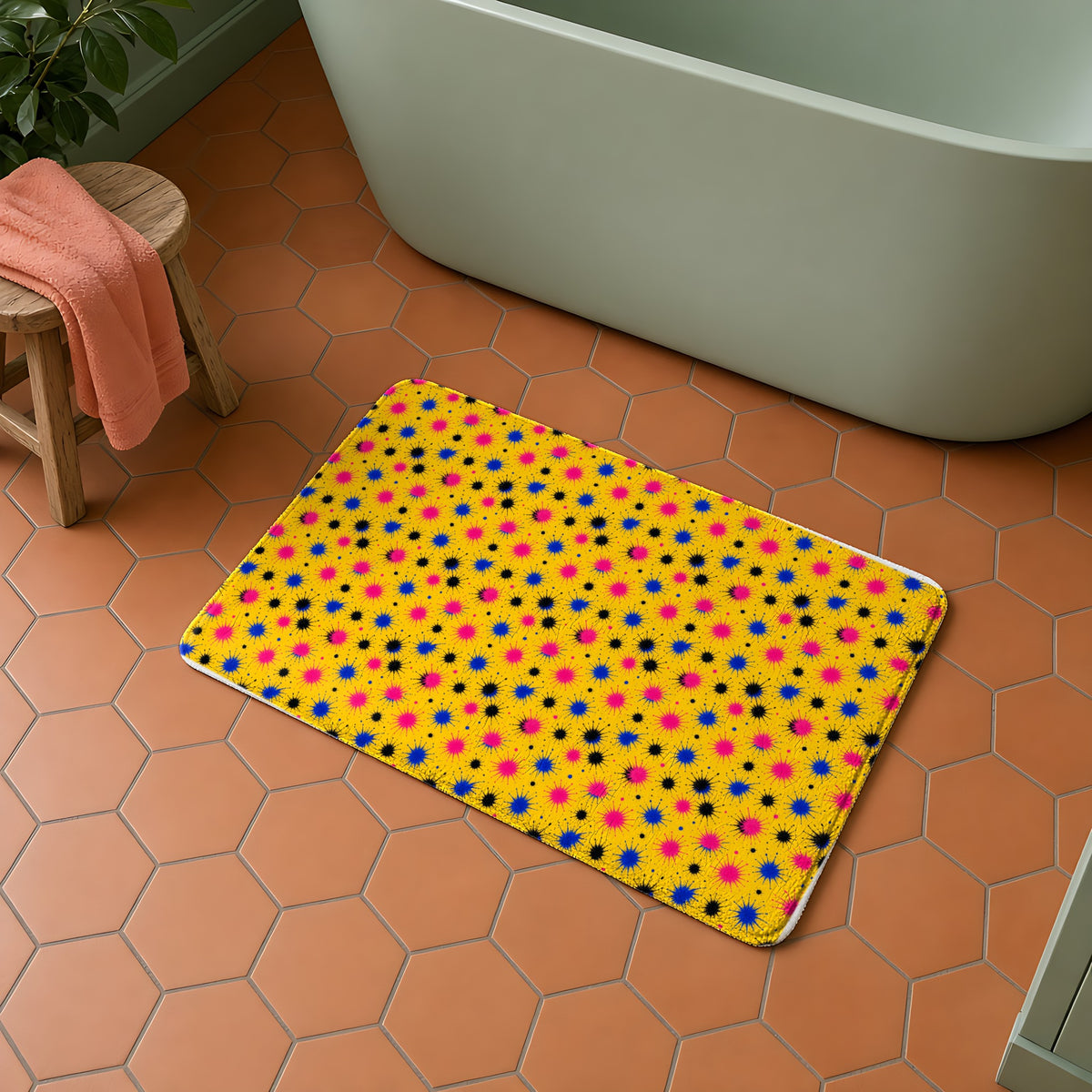 Splash Crowns bath mat in the Ink Splash Riot palette, on a terracotta hexagon-tile floor beside a sage-green bath