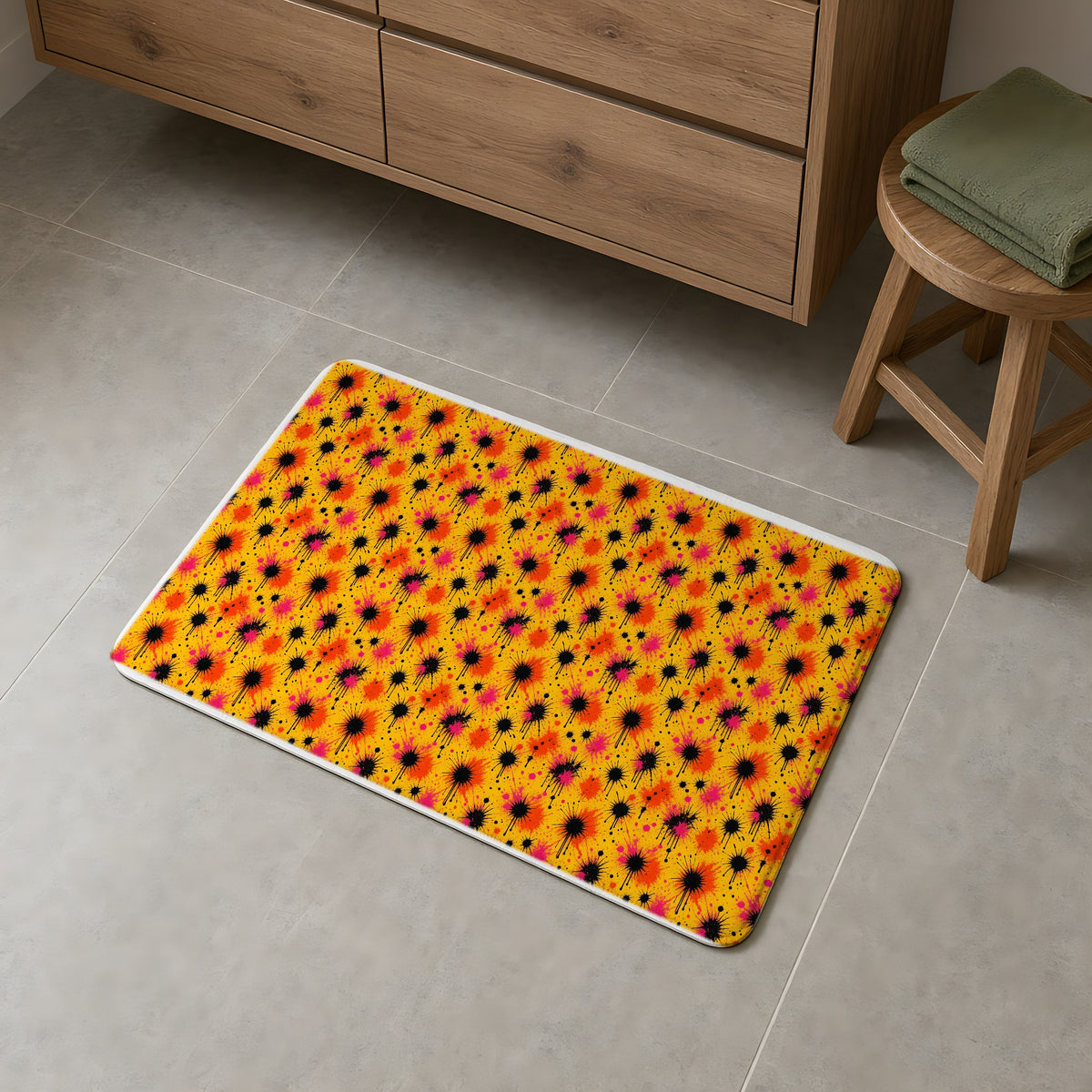 Black Ink Burst Bath Mat on a grey tiled bathroom floor