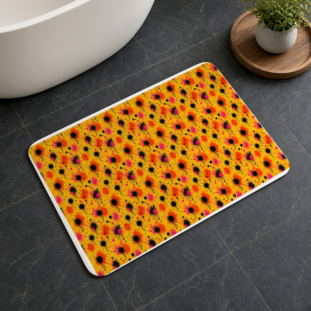 Black Ink Burst Bath Mat on a dark slate floor beside a bath
