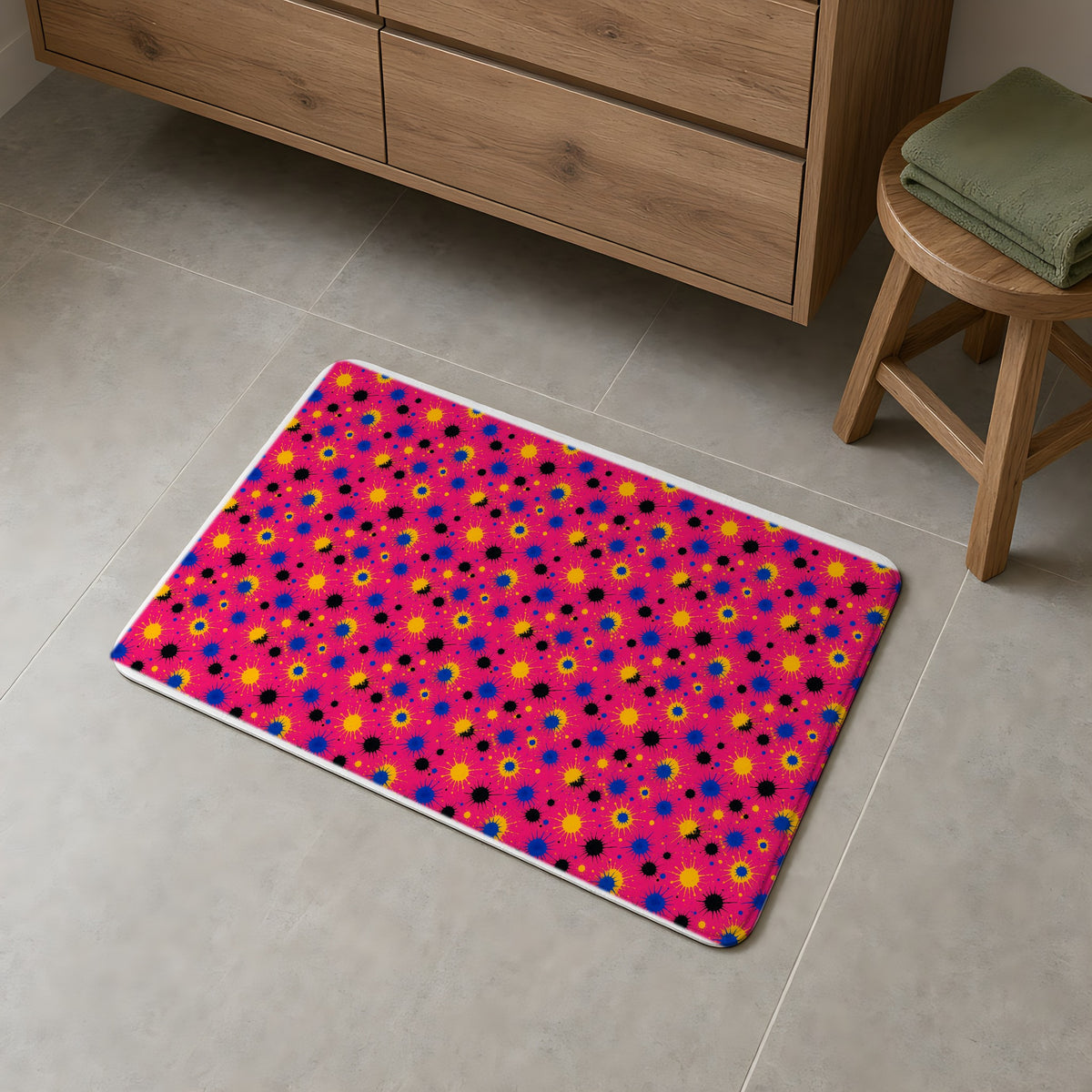 Pink Ground Splash Bath Mat on a grey tiled bathroom floor