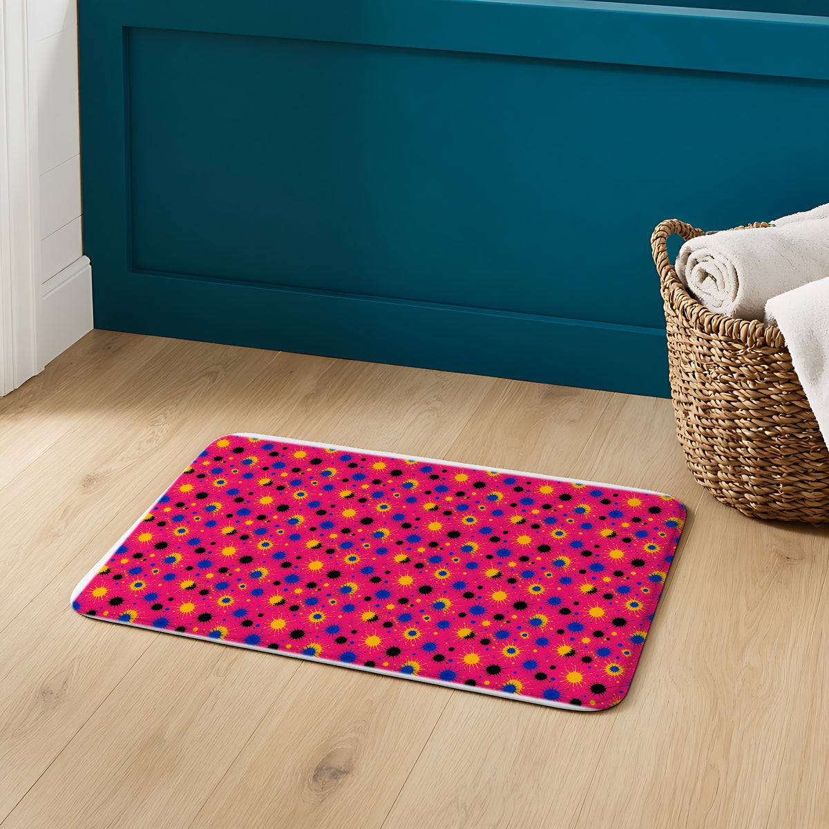 Pink Ground Splash Bath Mat on an oak floor in a teal bathroom