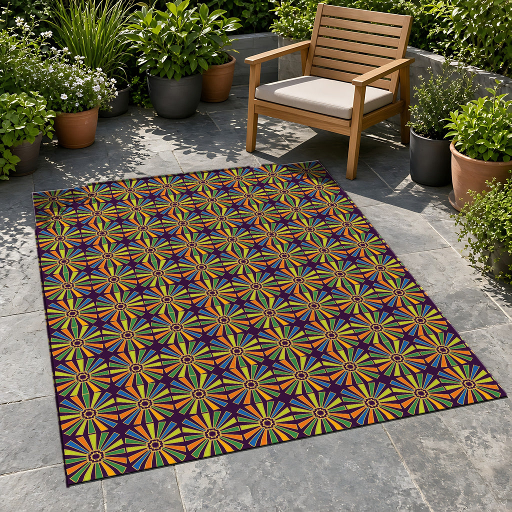 Sunray Medallion Grid Outdoor Rug on a stone patio with potted plants