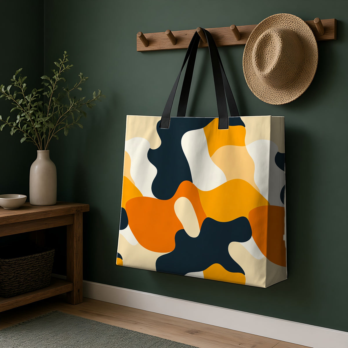 Orange Blob Camo Weekender Tote Bag hanging on a peg rail in a green hallway
