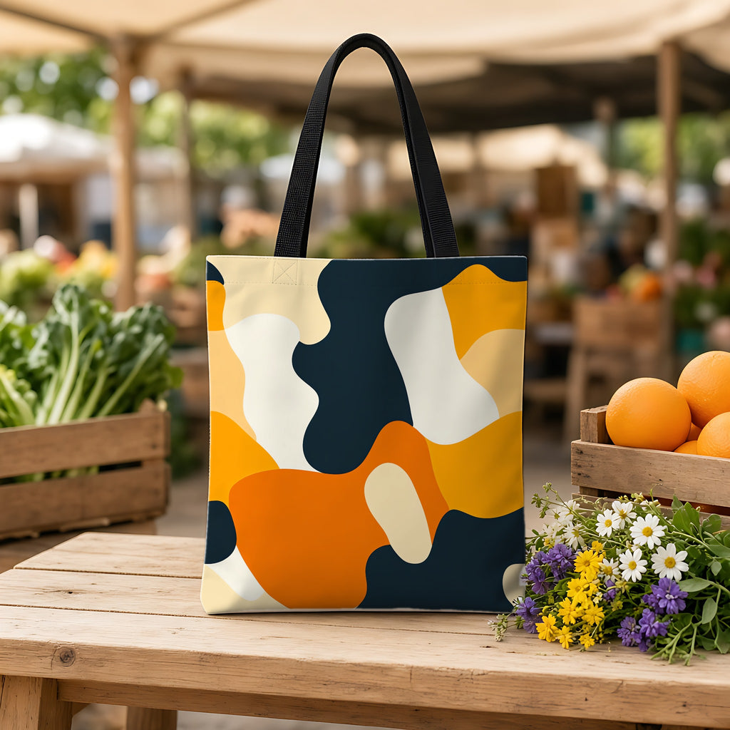 Orange Blob Camo Weekender Tote Bag on a wooden bench at a farmers market