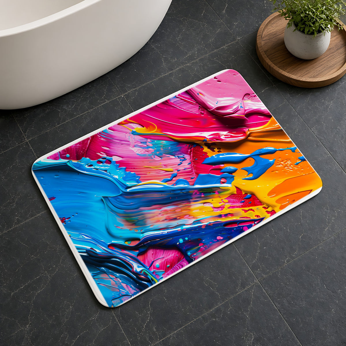 Rainbow Paint Smear Bath Mat on a dark slate floor beside a bath