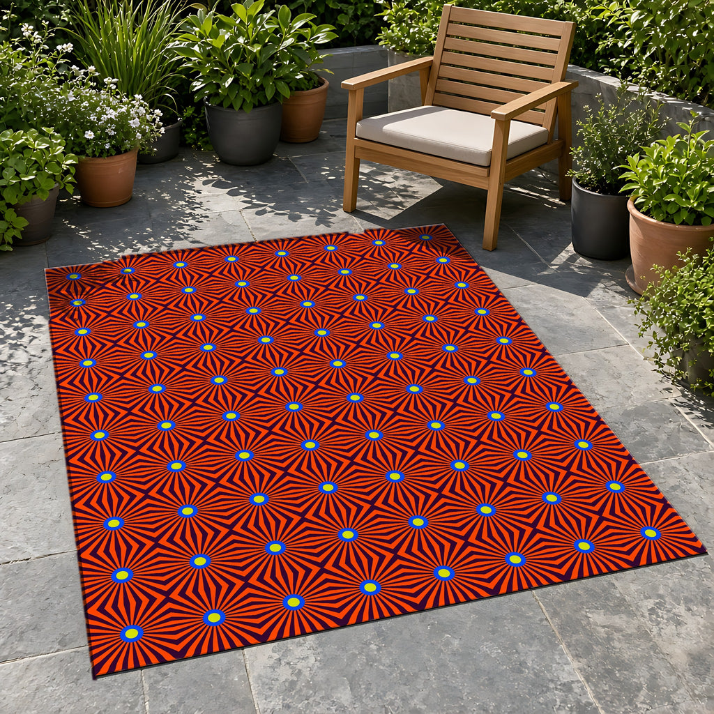 Starburst Stripes Outdoor Rug on a stone patio with potted plants