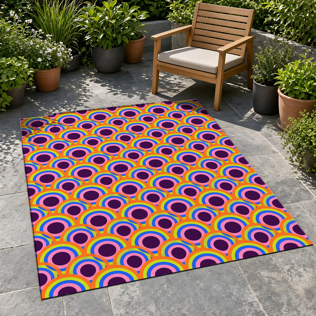 Pop Op Circles Outdoor Rug on a stone patio with potted plants