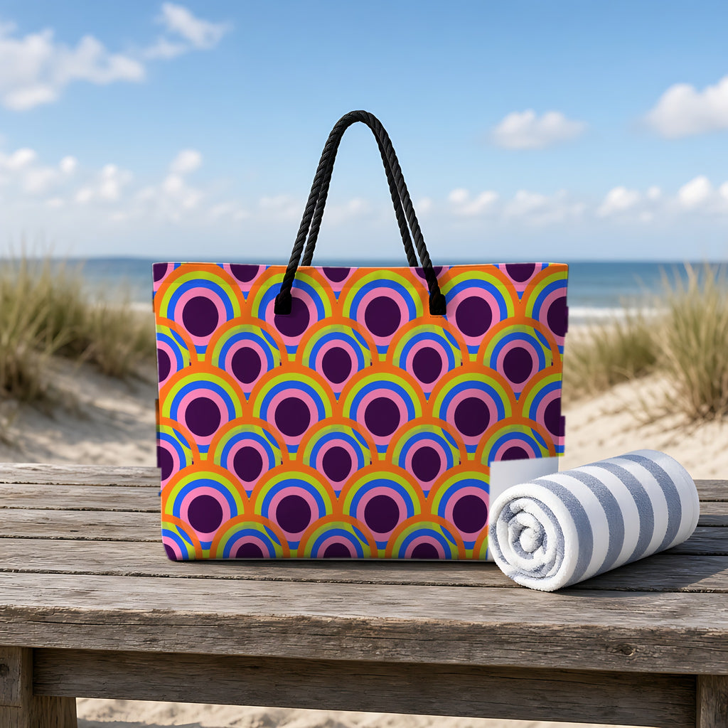 Pop Op Circles Weekender Tote Bag on a rustic table by the beach