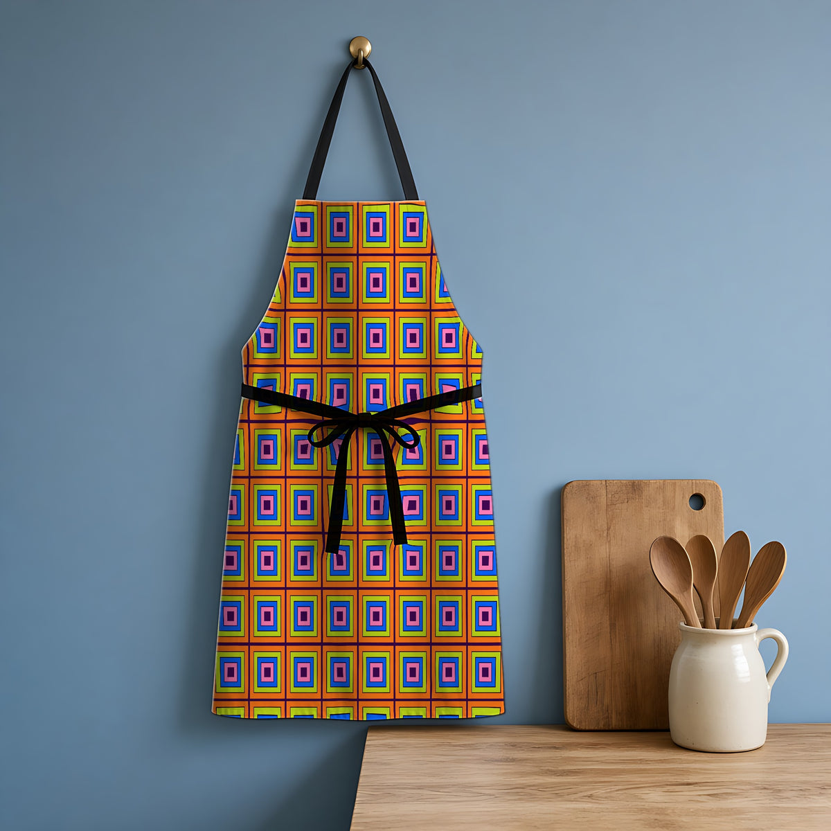 Concentric Square Pop Apron hanging in a blue kitchen