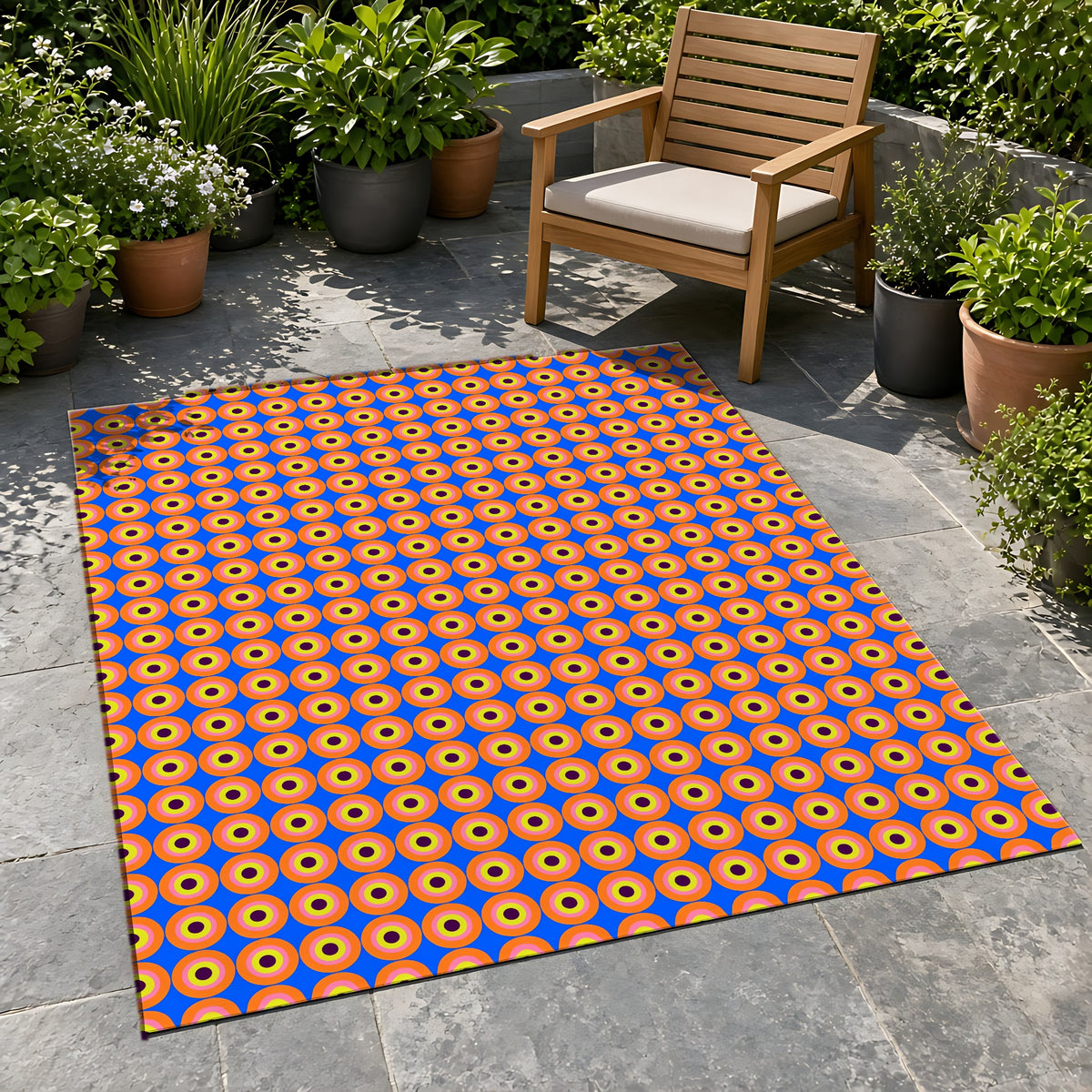Pop Target Dots Outdoor Rug on a stone patio with potted plants