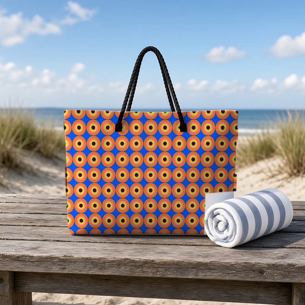Pop Target Dots Weekender Tote Bag on a rustic table by the beach
