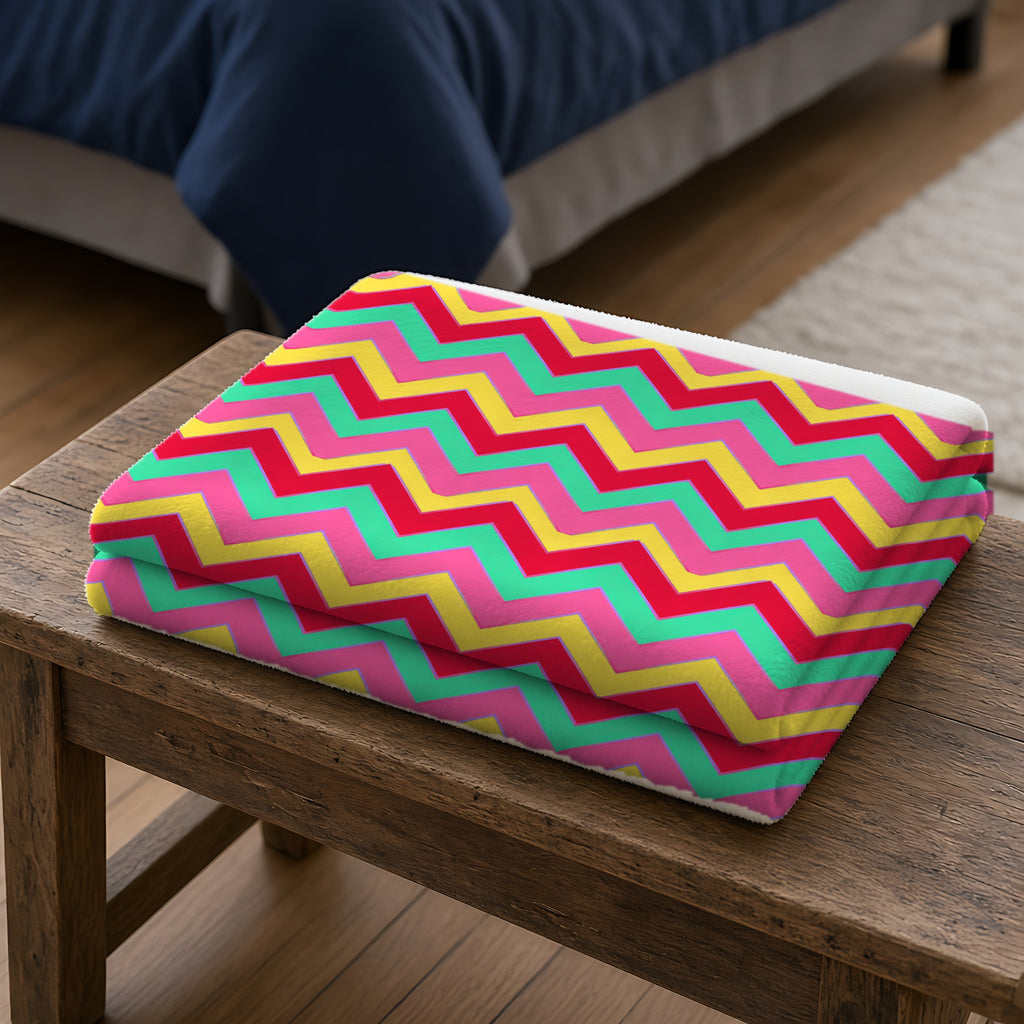 Jewel Chevron Bands Sherpa Fleece Blanket folded on a wooden bench