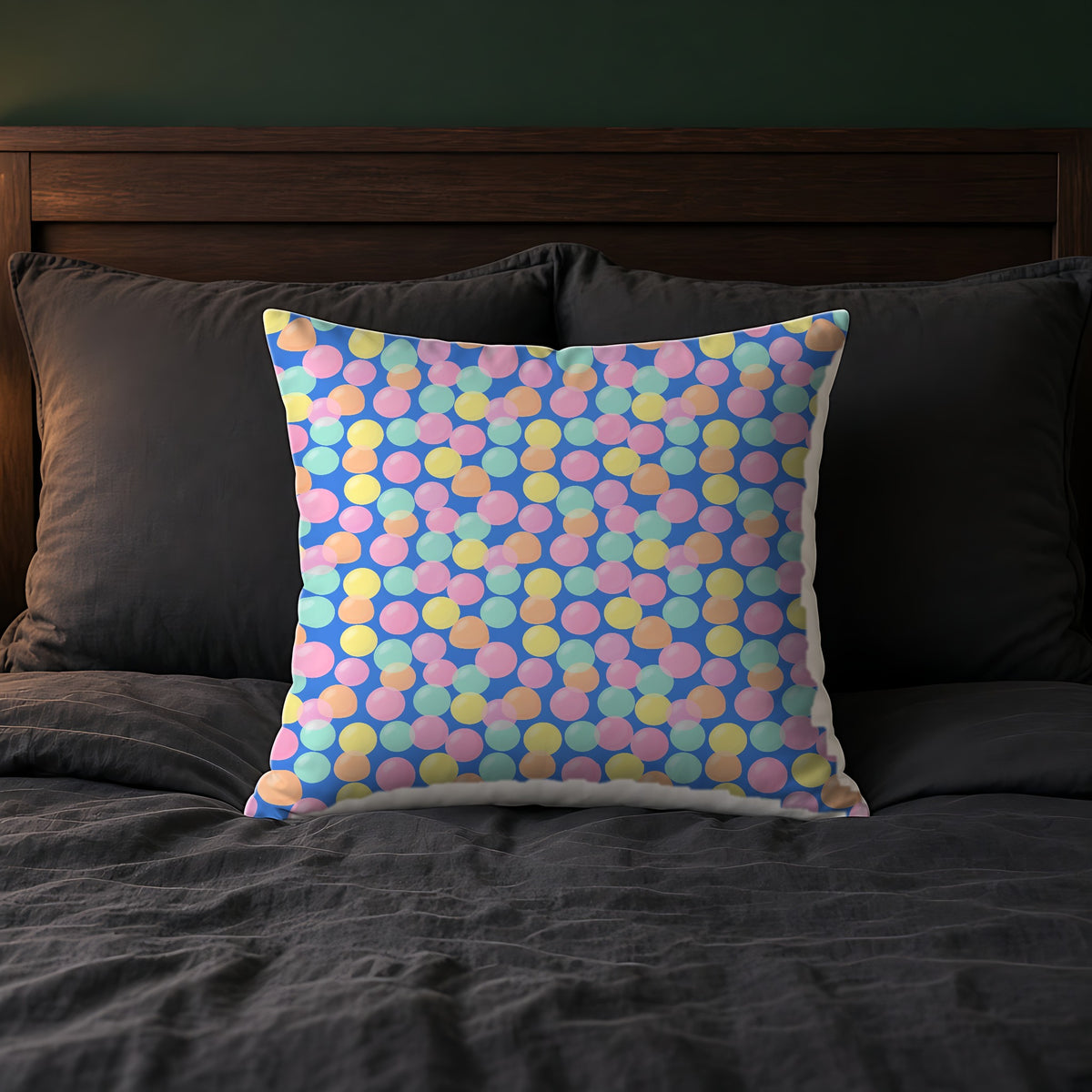 Gumdrop Orbs Faux Suede Cushion on a bed with charcoal bedding
