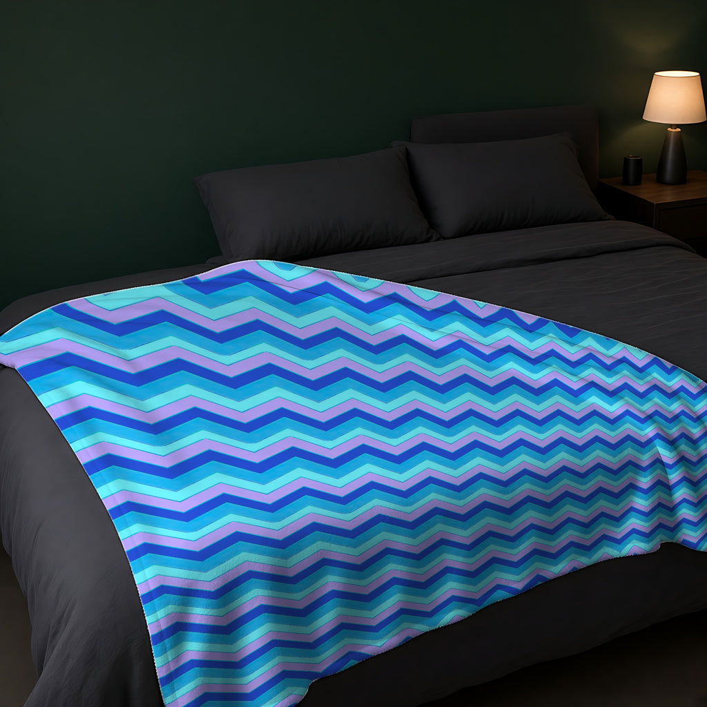 Jewel Chevron Bands Sherpa Fleece Blanket across the foot of a dark bed