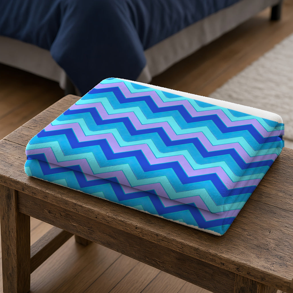 Jewel Chevron Bands Sherpa Fleece Blanket folded on a wooden bench