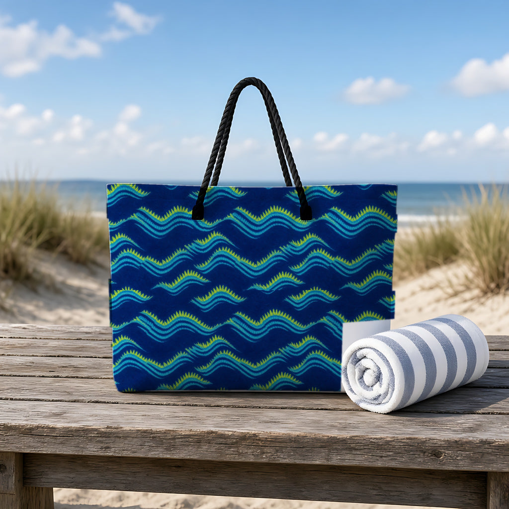 Pleat Wave Dye Weekender Tote Bag on a rustic table by the beach