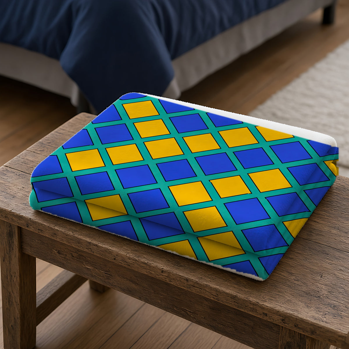 Harlequin Gold Grid Sherpa Fleece Blanket folded on a wooden bench