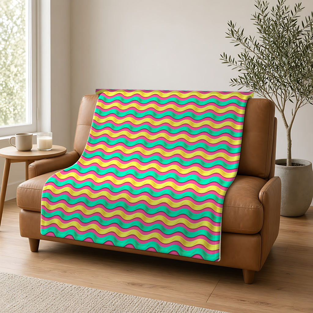 Satin Wave Bands Sherpa Fleece Blanket draped over a caramel leather sofa