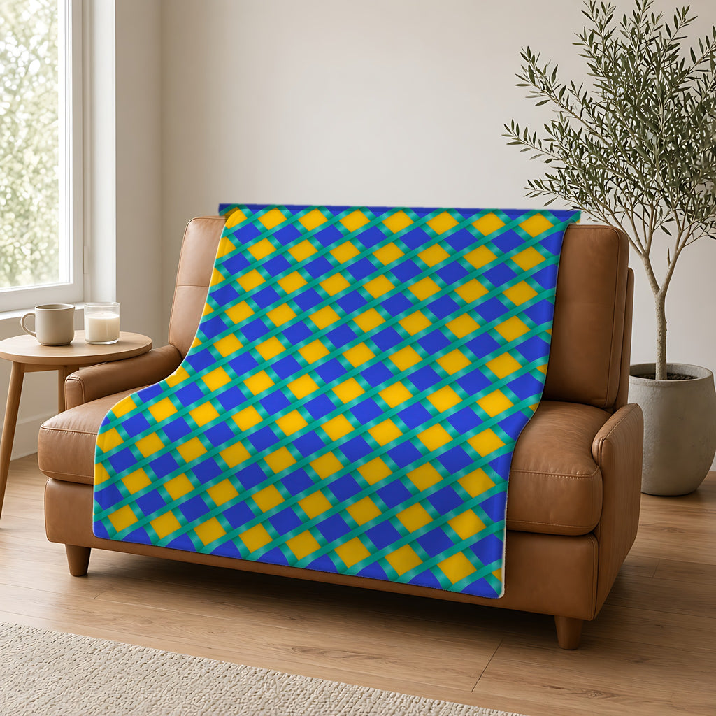 Broad Gold Diamond Trellis Sherpa Fleece Blanket draped over a caramel leather sofa