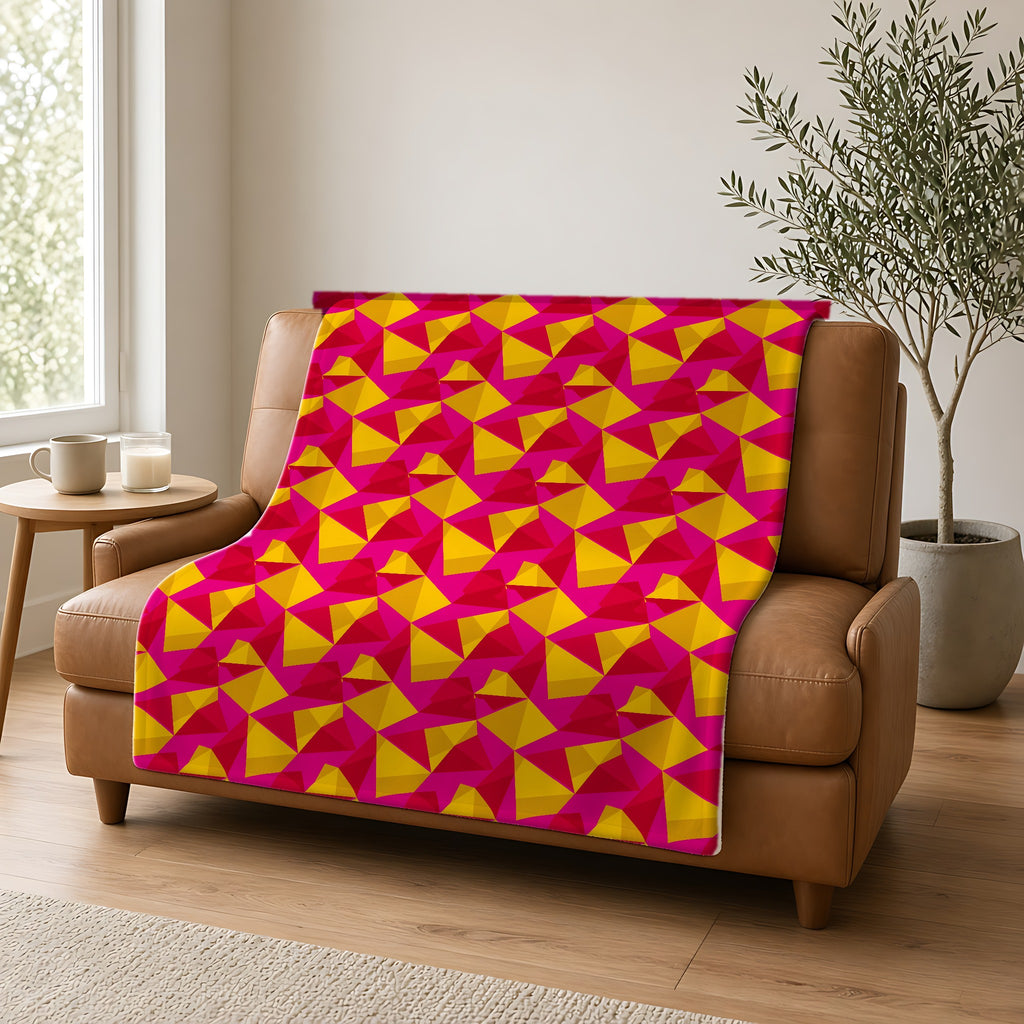 Faceted Gold Panels Sherpa Fleece Blanket draped over a caramel leather sofa