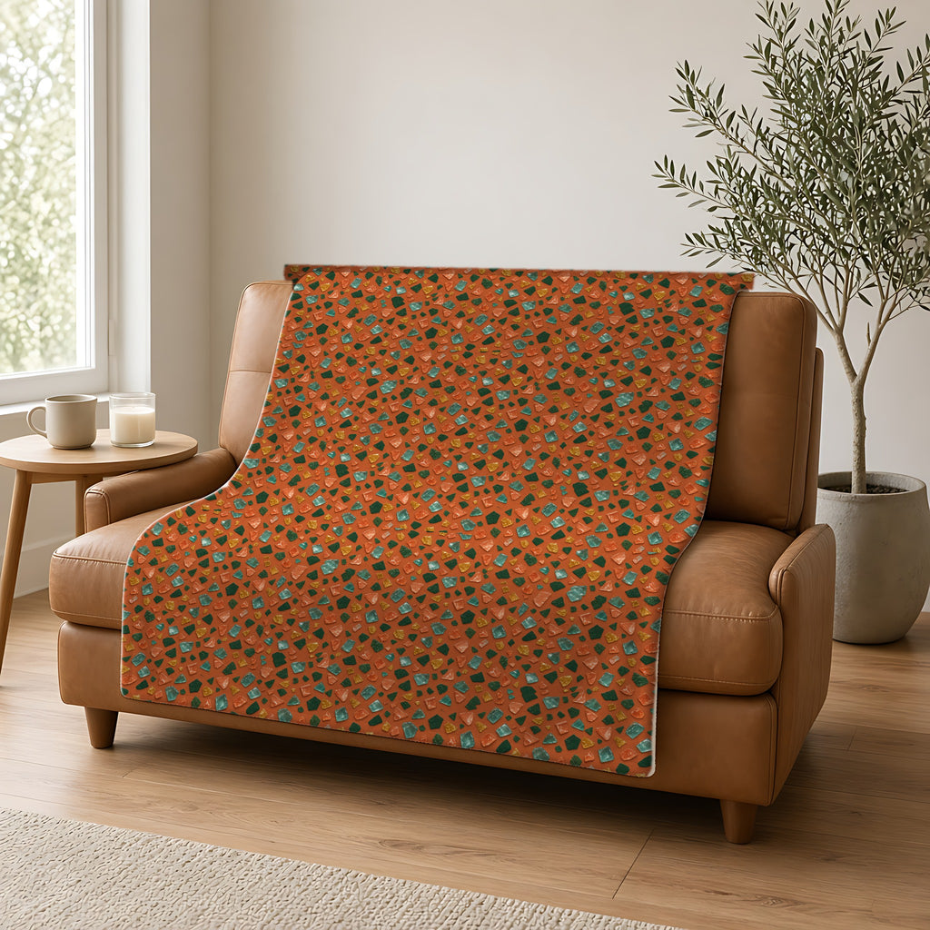 Glass Chip Sheen Sherpa Fleece Blanket draped over a caramel leather sofa