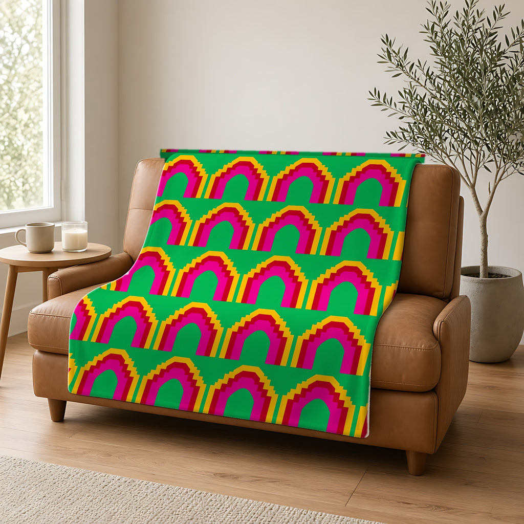 Grand Stepped Arches Sherpa Fleece Blanket draped over a caramel leather sofa
